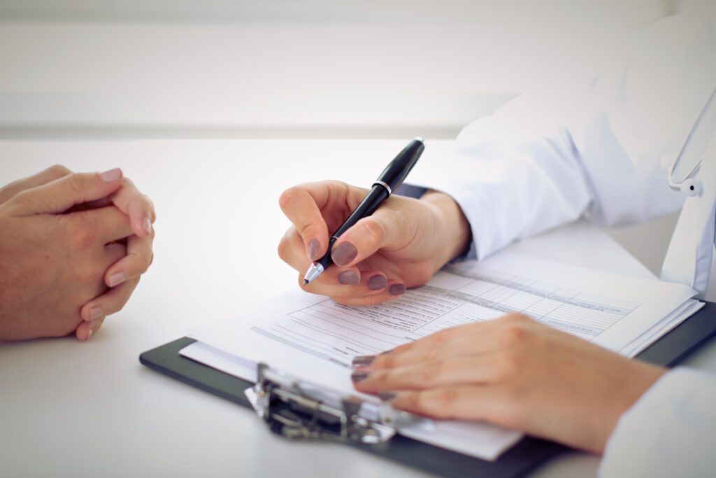 HSTI A doctor is signing a document, advancing in their career path with a patient.
